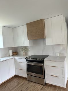 an empty kitchen with white cabinets and stainless steel stove top oven, dishwasher and microwave