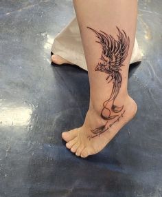 a woman's foot with a tattoo on it and a bird in the middle