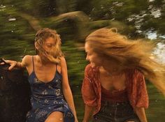 two young women are sitting on the back of a boat