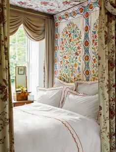 a bed sitting under a window in a bedroom