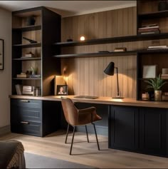 a home office with dark wood paneling and black cabinets, along with a brown leather chair