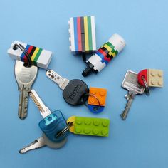 several lego keychains and keys on a blue surface