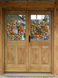 two double doors with flowers on them and glass panes above the doors are made of wood