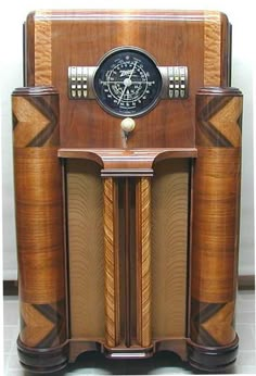 an old fashioned wooden clock sitting on top of a table