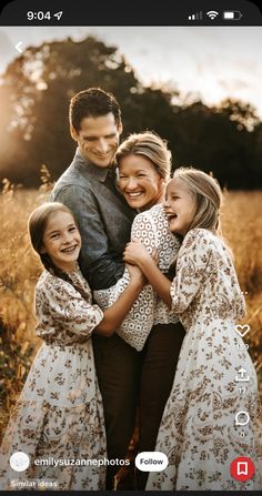 a family hugging each other in the middle of a field