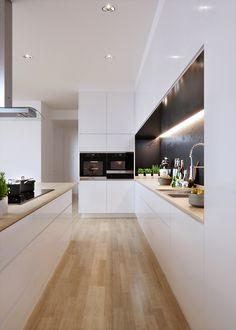 a modern kitchen with white cabinets and wood flooring on the walls, along with potted plants