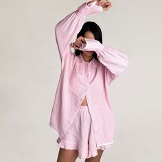 Description:Sweet dreams await in our pink designer pajama set. Crafted from soft cotton gauze. it's the epitome of comfort and charm. The lapel collar adds a touch of sophistication. while the contrast scalloped trim on the top enhances its sweetness. With a buttoned blouse featuring bicolor lace-trim long sleeves and a handy pocket on the right. it's as practical as it is pretty. The high waist band ensures a relaxed fit. perfectly complemented by the loose-fitting shorts adorned with delicate ruffles. Slip into this two piece pajama set and drift off into a world of serene elegance and cozy bliss. Top (in) S M L Length 27.6 28.0 28.3 Shoulder 26.6 27.4 28.1 Bust 41.3 42.9 44.5 Sleeve 18.7 18.9 19.1 Bottom (in) S M L Length 13.6 14.0 14.4 Waist 26.0 27.6 29.1 Hip 40.2 41.7 43.3 Fashion Pajamas, Cotton Pajama Set Women, Designer Pajamas, Two Piece Pajama Set, Pajama Set Long, Cotton Pajama Set, Homewear Woman, Collared Shirt Dress, Ruffled Blouse