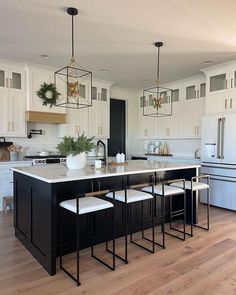 a kitchen with white cabinets and black island