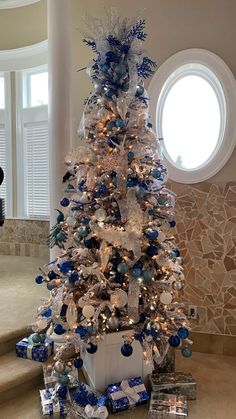 a white christmas tree with blue and silver ornaments