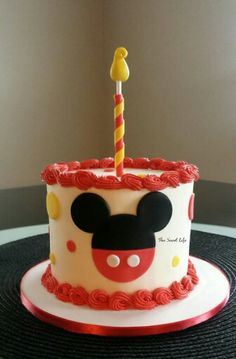 a mickey mouse cake with a candle on top