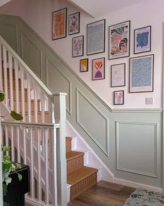 a staircase with pictures on the wall and carpeted stairs leading up to it's second floor