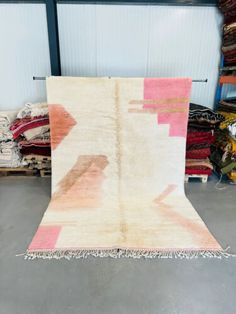 an area rug with pink and orange designs on it in front of a warehouse door