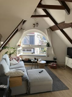 a living room with an arched window and white furniture