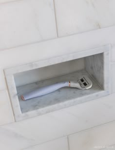 a white electric toothbrush in a marble niche