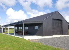 a large metal building sitting on top of a lush green field