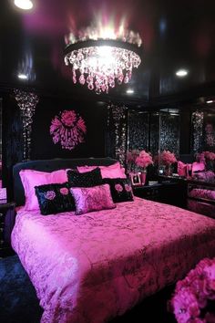 a bedroom with black walls and pink bedspread, chandelier and pillows