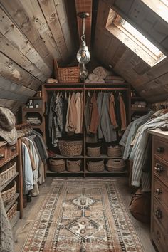 an attic bedroom with wooden walls and flooring is furnished with baskets, rugs, and clothes