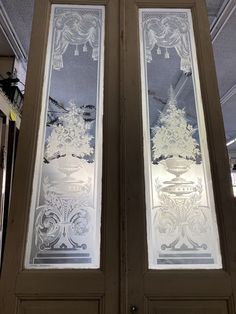 two glass doors with decorative designs on them