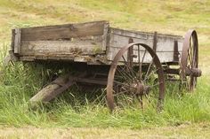 an old wooden wagon sitting in the grass