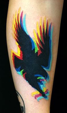 a colorful tattoo with an eagle on the leg