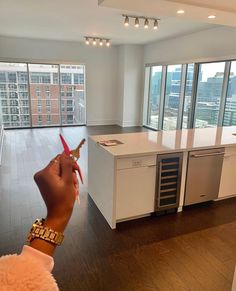 a person holding a pair of scissors in front of an empty kitchen and living room