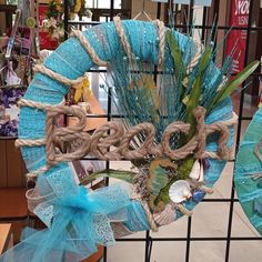 a blue wreath with the word beach hanging from it's side in front of a store display