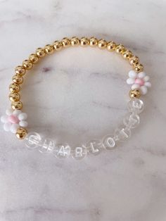 This listing is for your choice of an adult or child custom name bracelet with the daisy's as seen on bracelet. If you would prefer a different color letterbead please just message me so I can send you pictures of what I have. You will also be able to choose between gold-filled or gold-plated beads. The difference is the quality and will reflect in the price. The beads look the same but gold-filled can be worn in water and will not tarnish over time. For accurate measuring, please make sure to t Customizable Adjustable Letter Name Bracelet, Cute Personalized Gold Stretch Bracelet, Trendy White Beaded Bracelets With Name, Customized Cute Gold Name Bracelet, Personalized White Letter Name Bracelet, Cute Customized Name Bracelet With Round Beads, Personalized Cute Gold Beaded Bracelets, Cute Gold Name Bracelet For Friendship, Customizable Gold Name Bracelet In Cute Style