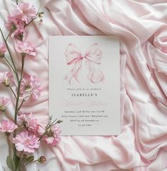 a wedding card with a pink bow on it and flowers in front of the card