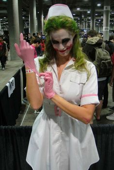 a woman dressed as a nurse is posing for the camera in front of a crowd