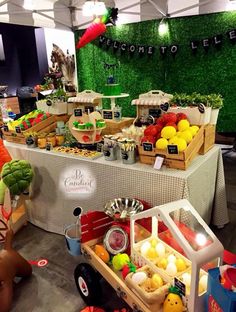 an assortment of fruits and vegetables on display at a farmers'market with green walls