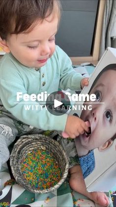 a baby is playing with sprinkles in front of a photo and the caption reads feedi tame