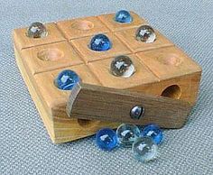 a wooden toy with blue glass beads on it's sides and a piece of wood in the middle