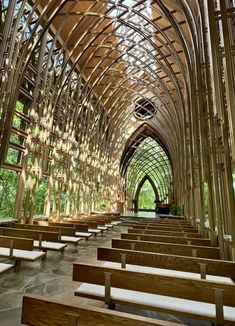 the inside of a church with wooden pews and benches lined up against the wall