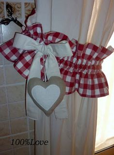 a red and white checkered bow hanging from the side of a window sill