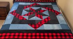 a bed with a red and black quilt on it