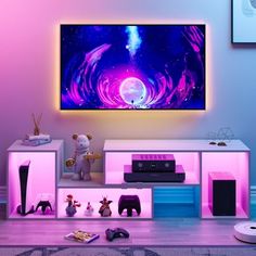 a living room with purple and blue lighting on the wall, television set in front of it