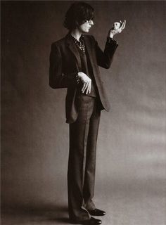 an old photo of a man in a suit and beaded necklace holding a bird