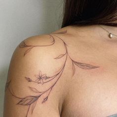 the back of a woman's shoulder with leaves on it