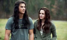 two people standing next to each other with long hair and green shirts on, in the rain