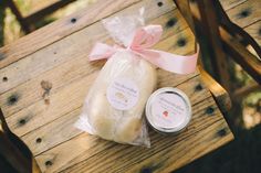 a bag of bread sitting on top of a wooden table next to a jar of jam