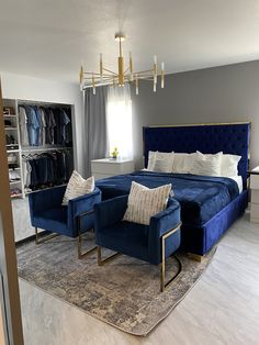 a bed room with a neatly made bed and two blue chairs