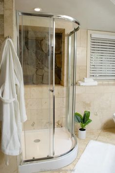 a bathroom with a stand up shower next to a toilet