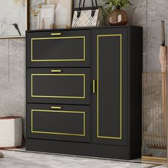 a black cabinet with yellow trim on the doors and drawers in front of a gray wall