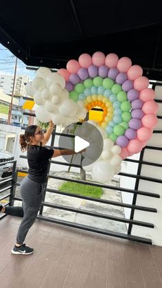 a woman is holding balloons in the air