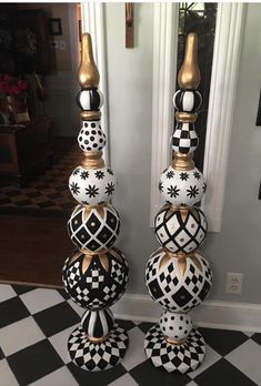 two black and white vases sitting on top of a checkered floor