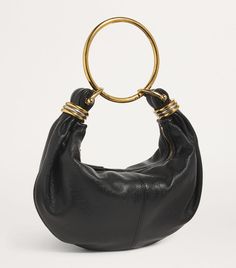 Find CHLOÉ Bracelet Top-handle Bag on Editorialist. The Chloé Bracelet bag is crafted from smooth leather and features a slouchy silhouette. It is suspended from a gold-tone ring handle, which gives the bag its name. The bag has a zip closure and is small in size. It can be worn on the shoulder or hand carried. Chloe Bracelet Bag, Chloe Mini Bag, Bracelet Bag, Tom Ford Clothing, Ring Handle, Gold Bag, Fine Watches, Luggage Accessories, Small Handbags