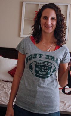 a woman standing in front of a bed holding a camera