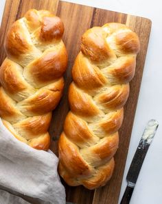 two loaves of bread sitting on top of a cutting board