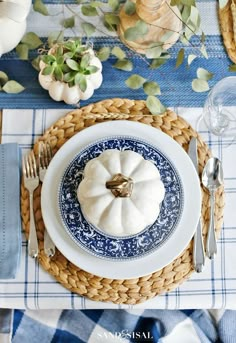 a blue and white place setting with pumpkins