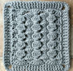 a crocheted square is sitting on the floor